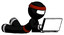 Ink Ninja Warrior Man using laptop computer while lying on floor side angled view