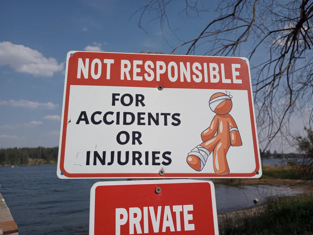 Close-up of a safety sign featuring the Orange Man with bandages and crutches.