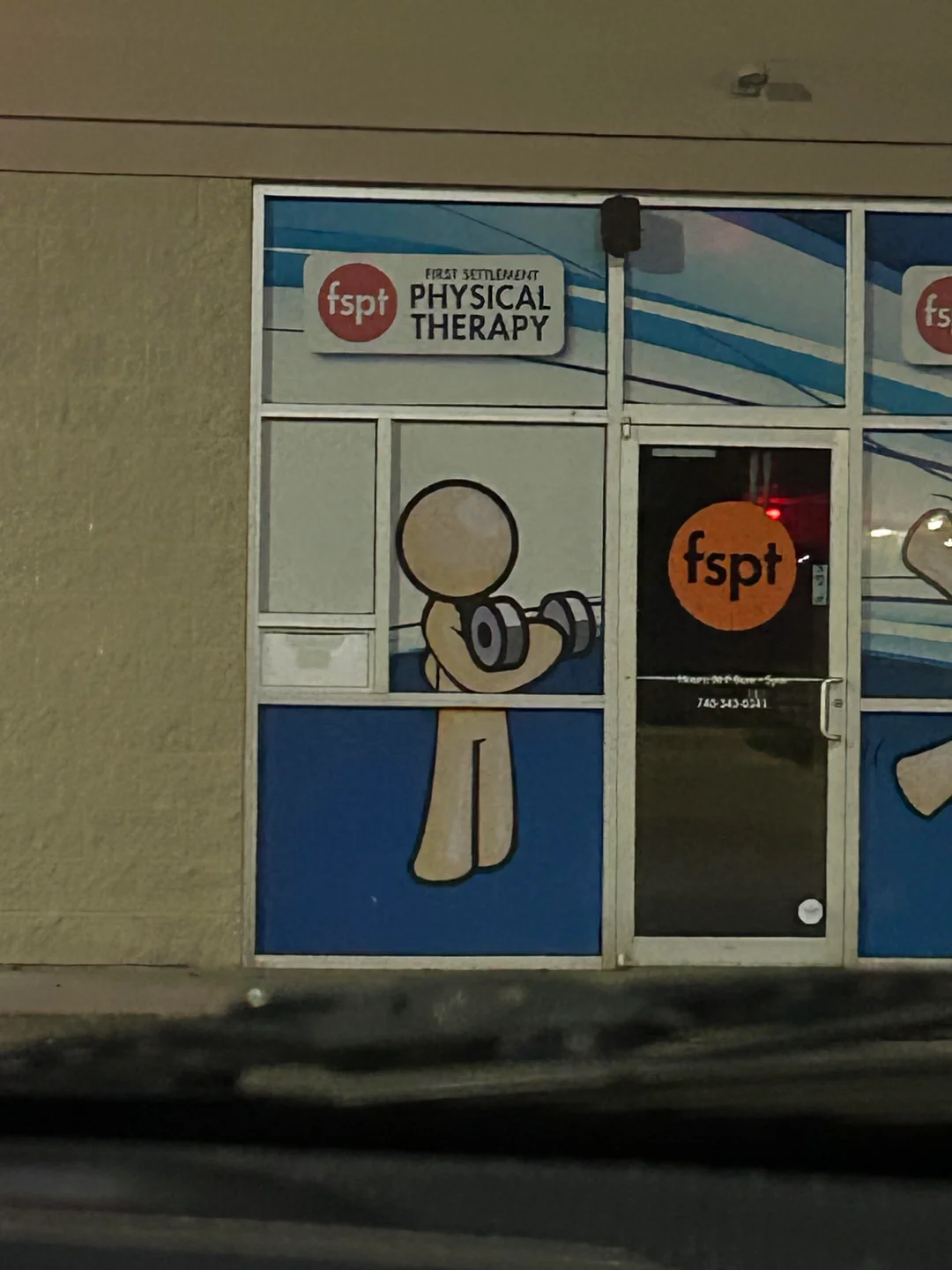 White design mascot lifting a dumbbell at a First Settlement Physical Therapy office.